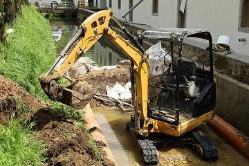 Escavatore ricostruisce argine canale post alluvione